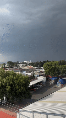Dark storm cloud approaches Puebla town rooftops