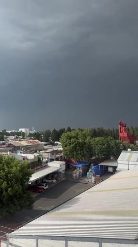 Dark storm cloud approaches Puebla town rooftops