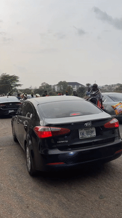 Motorcycle rider films black Kia on busy Abuja street