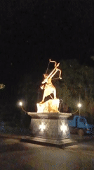 Golden warrior statue illuminated at night in Chopdem, India