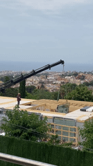 Crane installs glass rooftop structure in Spanish construction project