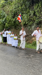 Buddhist procession walks through rural Makandura during rainy weather