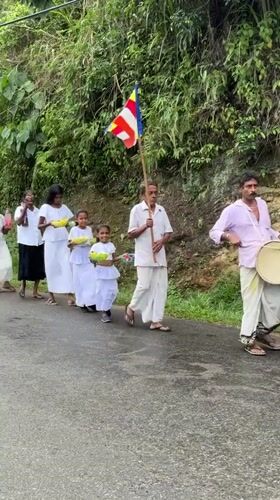 Buddhist procession walks through rural Makandura during rainy weather