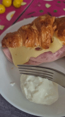 Croissant sandwich and boiled eggs at a Latvian breakfast table