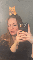 Woman takes mirror selfie video with decorated smartphone