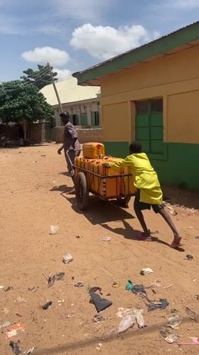 Carts and commerce moving through a Nigerian village road