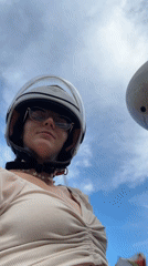 Woman rides motor scooter with passenger in Vietnam