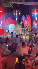Nighttime outdoor stage show in Jiyang District, dog in tow