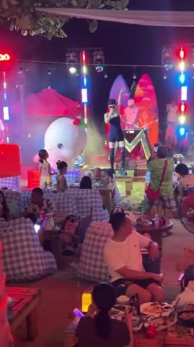 Nighttime outdoor stage show in Jiyang District, dog in tow