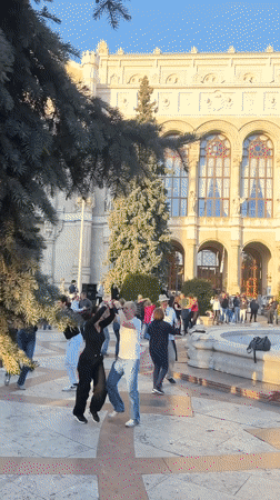 Couples dance salsa at Budapest public plaza fountain