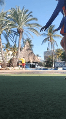 Person performs handstand on lawn near pool area