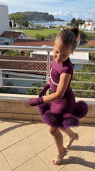 Young dancer poses on balcony overlooking Budva at dawn