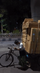 Man with bicycle cart collects cardboard in Dhaka