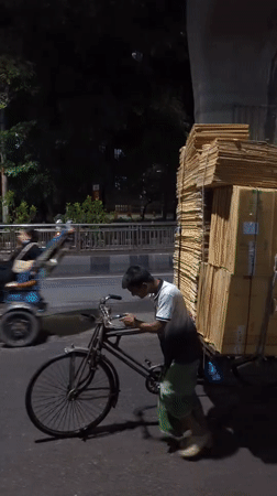 Man with bicycle cart collects cardboard in Dhaka