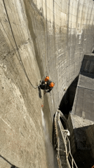 Worker rappels down French dam for maintenance cleaning