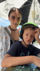 Boy and woman pose near food stand in Vietnam