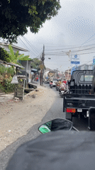 Mixed traffic flows through a busy Sukabumi street