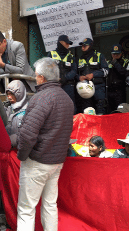 Crowds gather at La Paz tax office with guards present