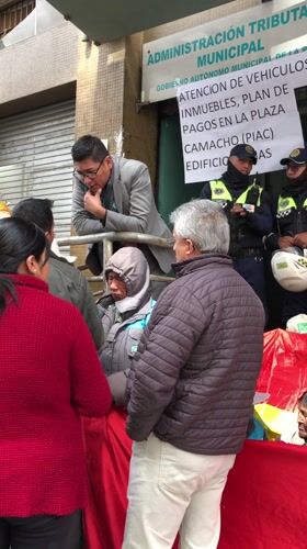 Crowds gather at La Paz tax office with guards present
