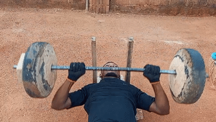Man exercises with homemade weights in Bukuru Nigeria