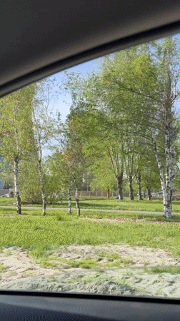 Car passes power plant cooling towers in sunny Cheboksary