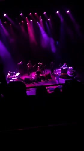 Live music performance observed in London with colorful stage lighting