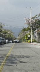 White car travels down street in Cuernavaca, Mexico