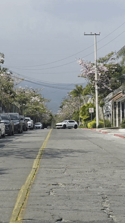 White car travels down street in Cuernavaca, Mexico
