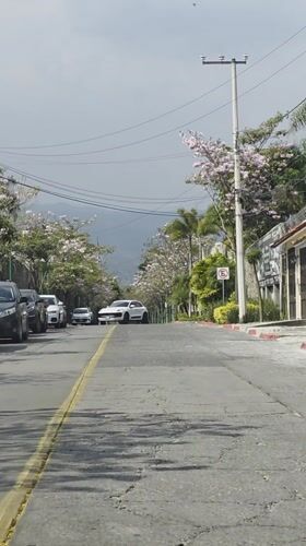 White car travels down street in Cuernavaca, Mexico
