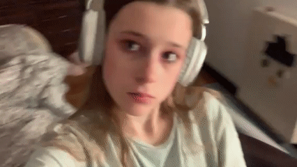 Woman applies pink makeup while wearing headphones in Belgrade