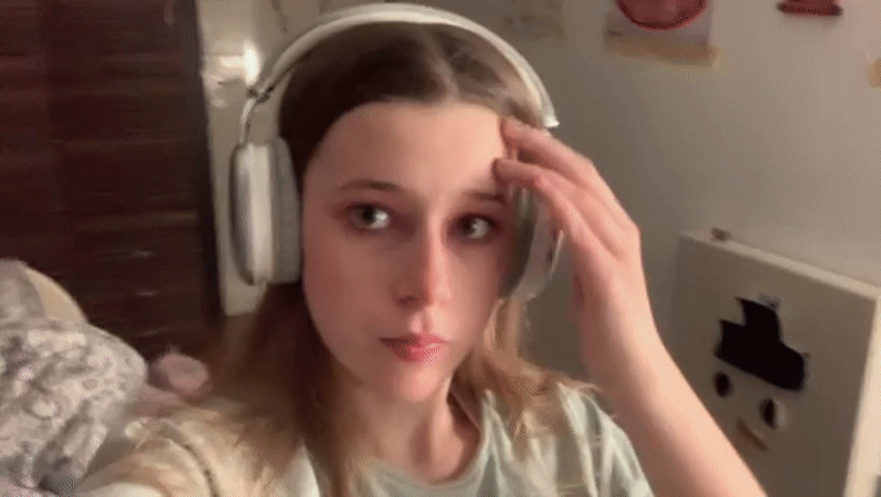 Woman applies pink makeup while wearing headphones in Belgrade