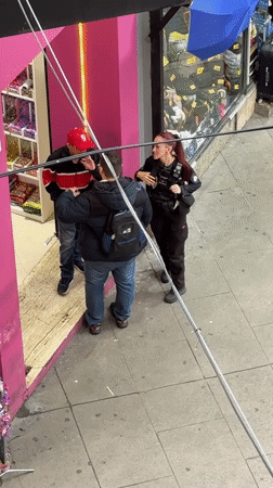 Police officer speaks with two men on Buenos Aires sidewalk