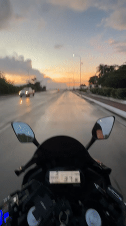 Motorcyclist rides wet Davao roads during dramatic sunset