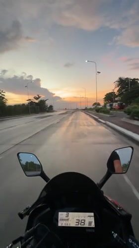 Motorcyclist rides wet Davao roads during dramatic sunset