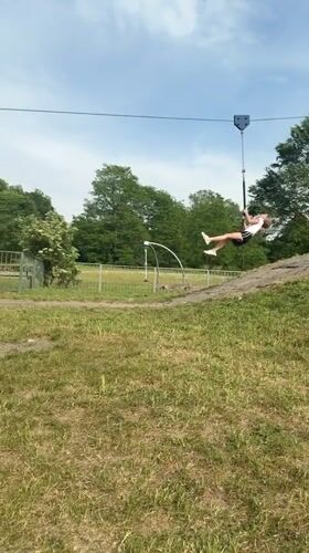 Girl plays at London park, rides zip line and cartwheels