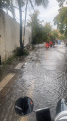 Scooter rider travels through flooded streets in North Kuta