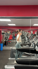 Woman uses phone while exercising on treadmill in Sofia gym