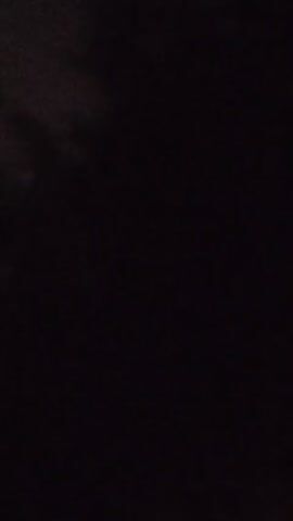 Here is a concise description of the video:

The video shows a single, blurry orange light in a dark environment. The light appears to be distant and remains relatively still throughout the brief clip. There is also a suggestion of trees faintly visible in the background.