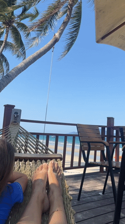 Woman enjoys peaceful hammock afternoon at beachside deck