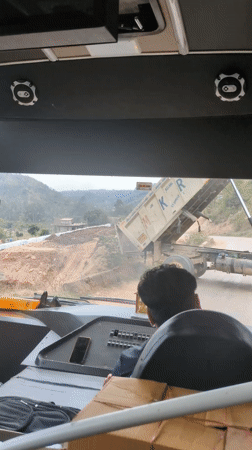 Dump truck deposits gravel on dirt road in Basa Balhu