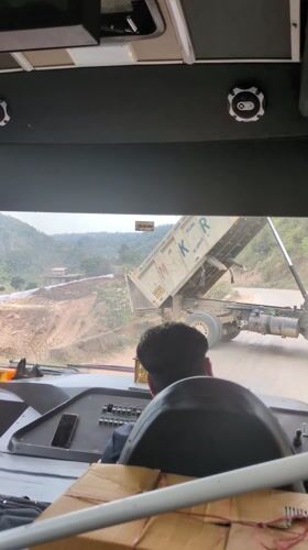 Dump truck deposits gravel on dirt road in Basa Balhu
