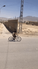 Boy rides bicycle through Quetta streets on clear morning