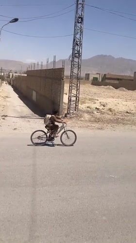 Boy rides bicycle through Quetta streets on clear morning