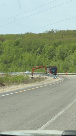 Dump truck transports excavator arm on Russian highway