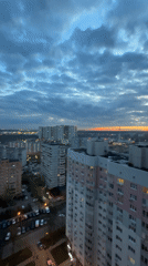 Moscow evening cityscape shows layered clouds with distant orange sunset