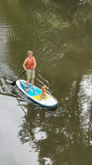 Woman paddles with dog on waterway in Stade