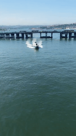 Small boat passes under bridge in Istanbul waters