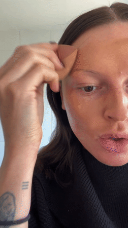 Woman demonstrates skincare routine in Langton Green bathroom