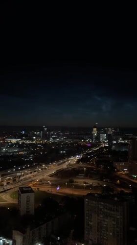 Khimki at night, noctilucent clouds over a lit cityscape