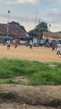 Pickup soccer match at dusk on a Jos neighborhood dirt field